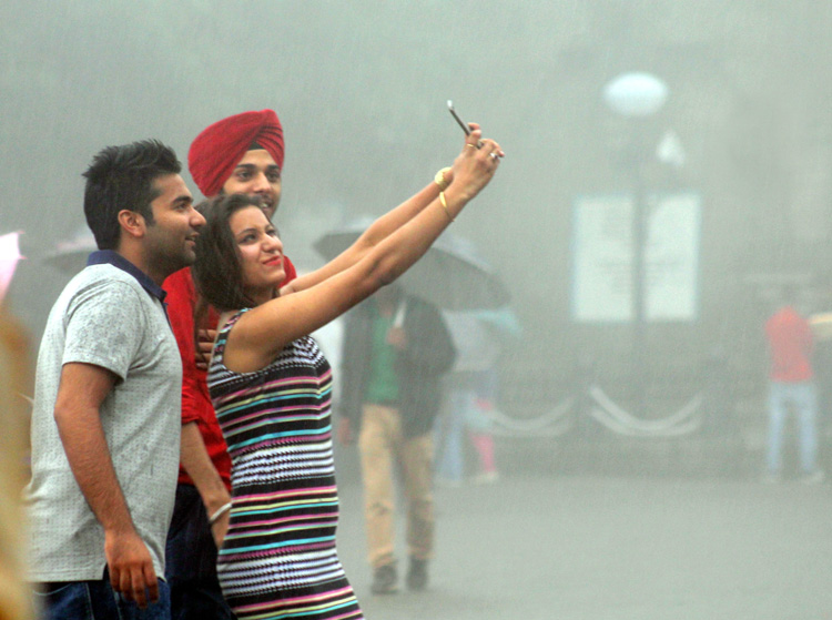 selfie - Indian teenagers taking a rain-drenched selfie in New Delhi. (Photo.. IANS)