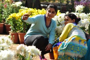 Jaipur: Girls click a `selfie` at a flower exhibition organised at Rajasthan University in Jaipur, on Dec 5, 2014. (Photo: Ravi Shankar Vyas/IANS)