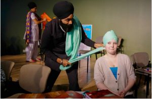 Harman Singh Goraya, a teacher from Calgary, wraps a turban for student Annika Roren. Photo:www.ualberta.ca