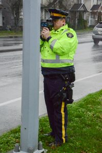 Despite the speed zone signs and digital speed displays, Const. Sid Jordan steps out to direct a speeder into a safe area to receive a speeding ticket.