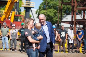 1.Premier John Horgan and Danielle Shaw, a young mother and ironworker apprentice with Local 97, celebrates the Community Benefits Agreement announcement with workers at the British Columbia Institute of Technology. Photo credit: Government of British Columbia.